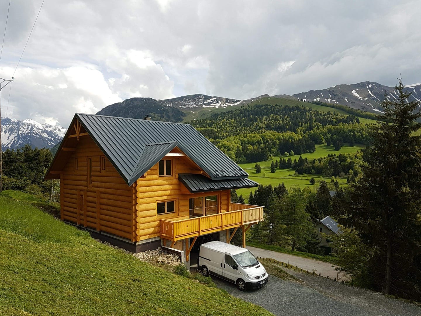Blockhaus aus Massivholz mit dunklem Blechdach in den Bergen